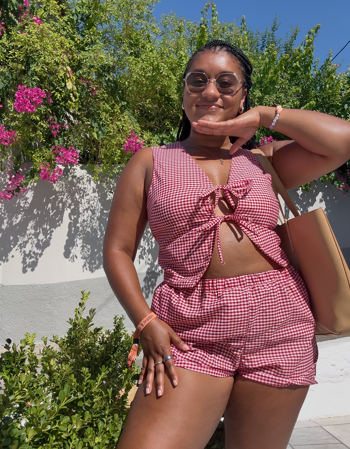 Owner (female) posing and smiling in red and white gingham print set